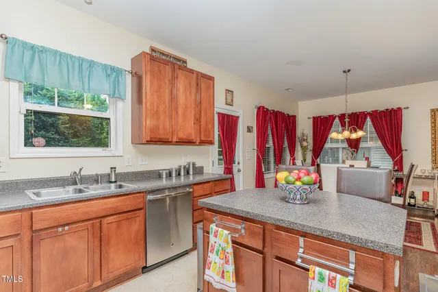 a kitchen with stainless steel appliances a sink window and cabinets