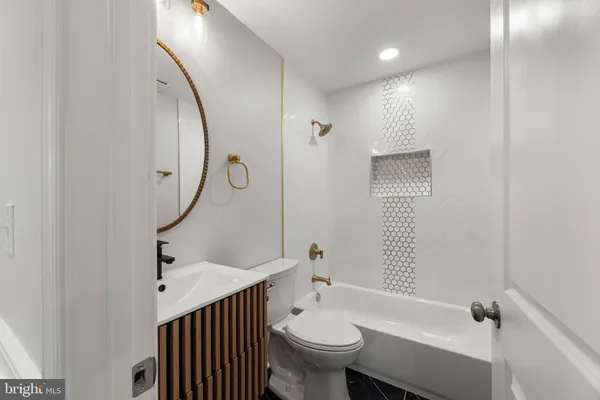a bathroom with a toilet a sink and mirror
