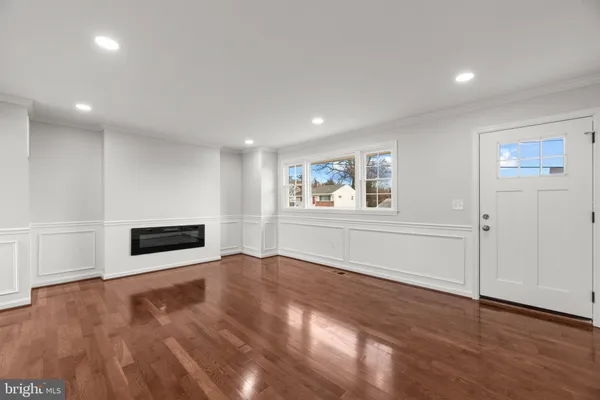 a view of empty room with wooden floor and window