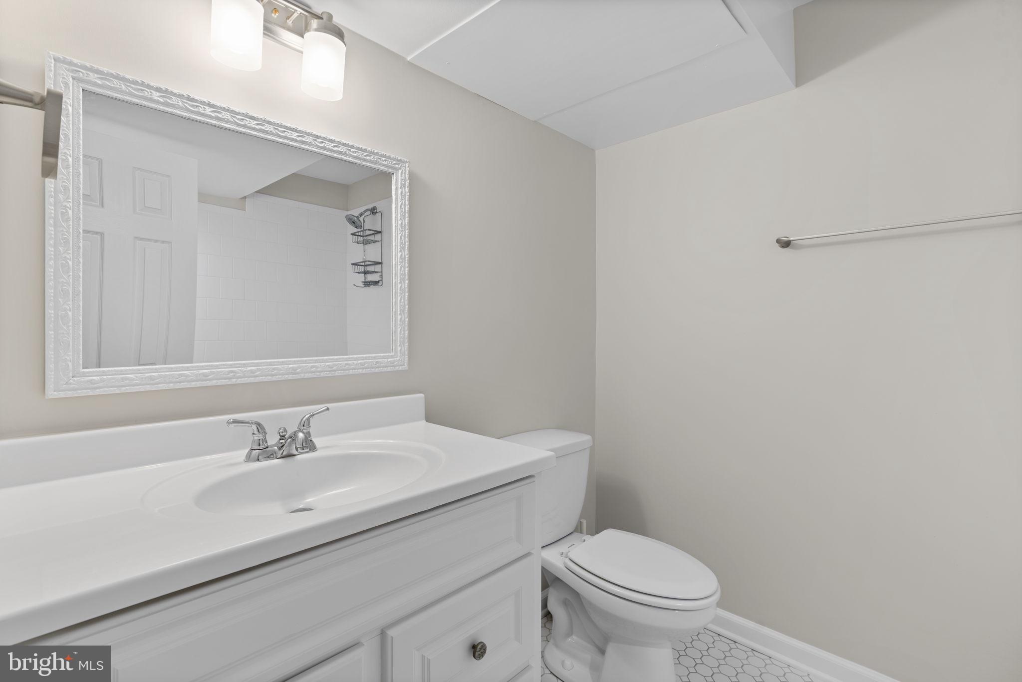 7818 Metacomet Road Hanover, MD 21076 - Photo 39 of 52 a bathroom with a granite countertop toilet a sink and a mirror