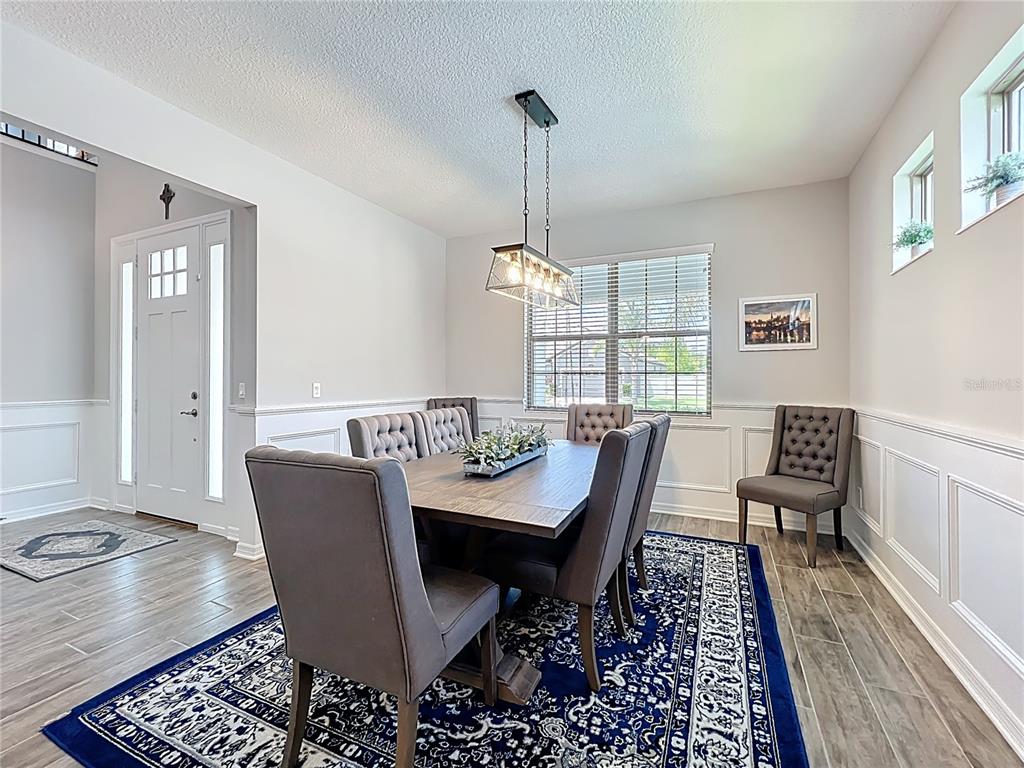 2676 Estuary Loop Oviedo, FL 32765 - Photo 12 of 92 a dining room with furniture a rug and wooden floor