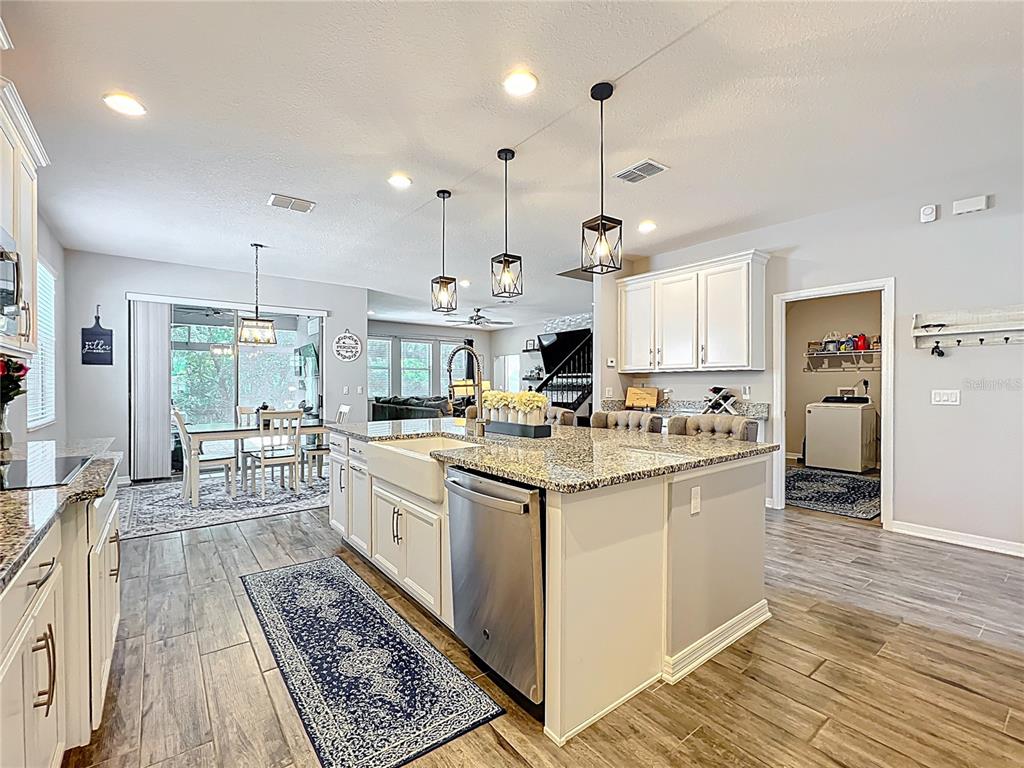 2676 Estuary Loop Oviedo, FL 32765 - Photo 15 of 92 a kitchen with stainless steel appliances kitchen island granite countertop a stove a sink and a refrigerator