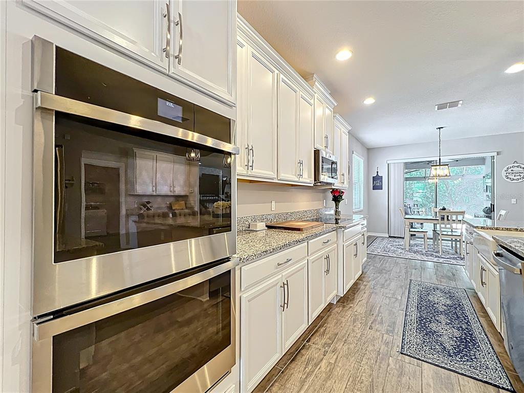 2676 Estuary Loop Oviedo, FL 32765 - Photo 21 of 92 a large kitchen with stainless steel appliances granite countertop a stove and a sink