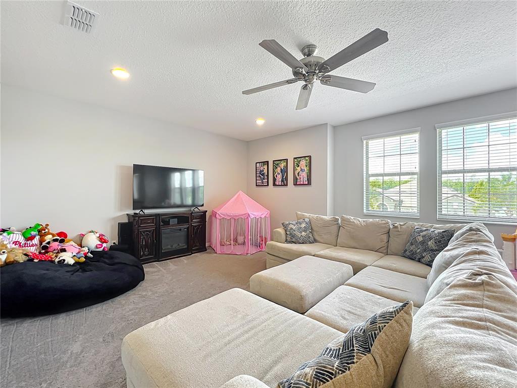2676 Estuary Loop Oviedo, FL 32765 - Photo 45 of 92 a living room with furniture chandelier and a flat screen tv