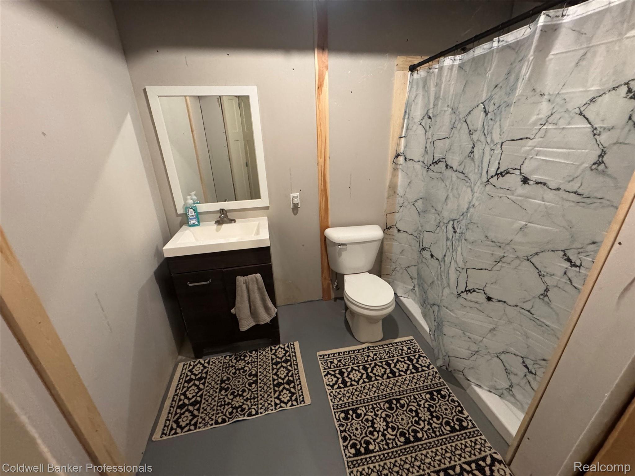 5323 English Road Clifford, MI 48727 - Photo 45 of 46 Vanity with a white basin and dark wood-finish cabinetry