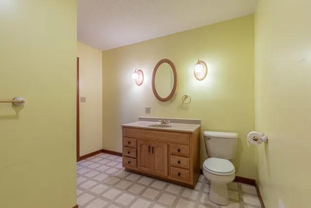 a bathroom with a toilet a sink and a mirror