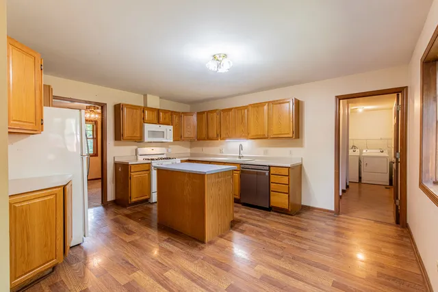 a kitchen with granite countertop a refrigerator stove top oven and sink