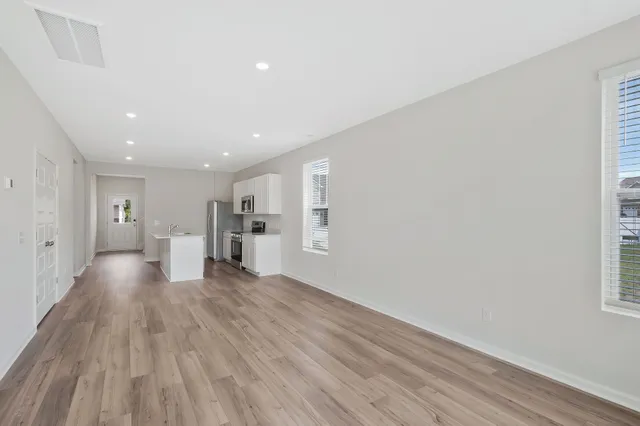 a view of a big room with wooden floor and windows