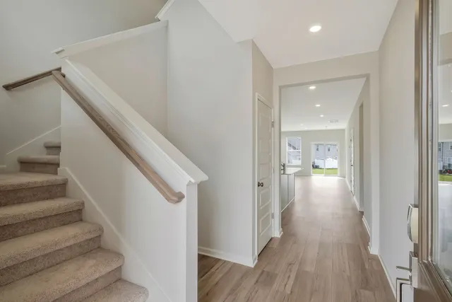 a view of a hallway with wooden floor and entryway
