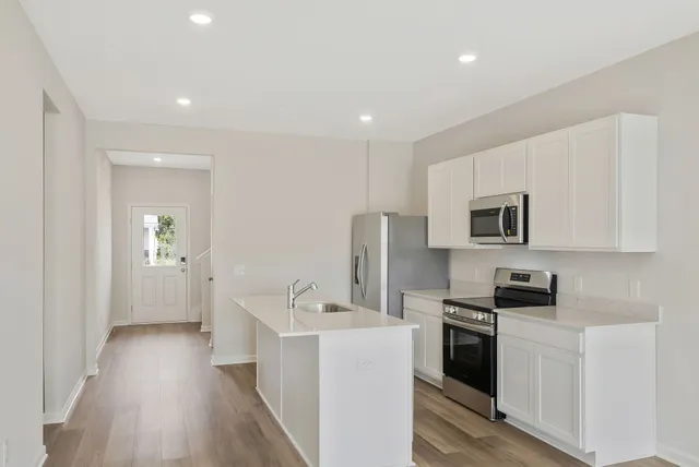 a kitchen with stainless steel appliances a refrigerator stove microwave and sink