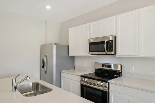 a kitchen with stainless steel appliances a stove a microwave and a refrigerator