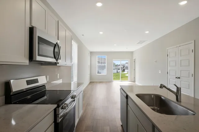 a kitchen with stainless steel appliances granite countertop a sink a stove and a microwave