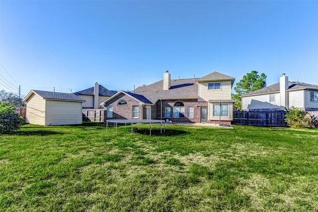 a view of a house with a big yard plants and large trees