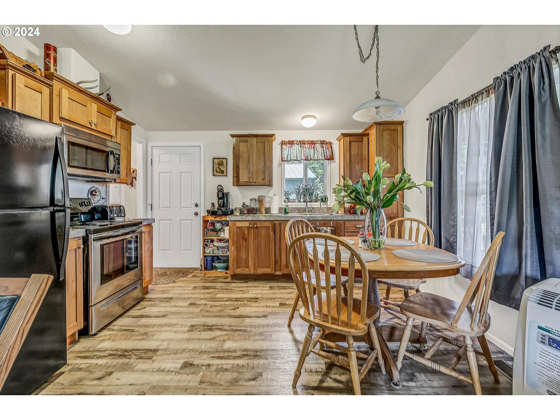 69911 Walker Road Rainier, OR 97048 - Photo 9 of 26 a kitchen with granite countertop a table chairs microwave and refrigerator