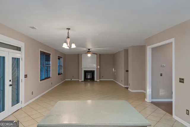 a view of a livingroom with a chandelier fan and windows