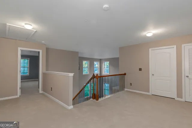 a view of an empty room with window and stairs