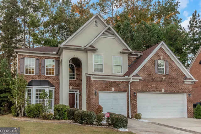 a view of a white house with large windows and a small yard