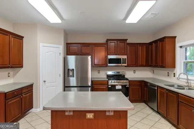 a kitchen with stainless steel appliances granite countertop a sink stove microwave and refrigerator