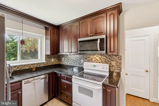 a kitchen with granite countertop cabinets stainless steel appliances and a sink