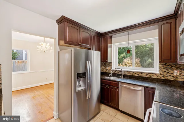 a kitchen with granite countertop a refrigerator and a sink