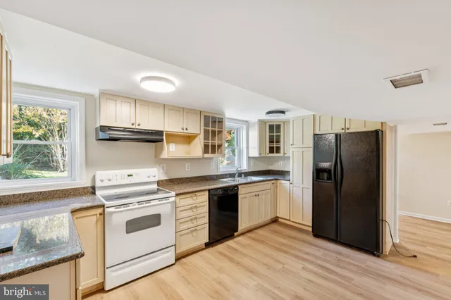 a kitchen with stainless steel appliances granite countertop a refrigerator stove and sink
