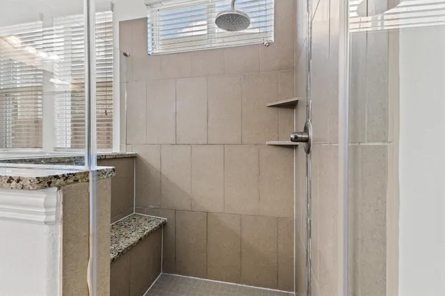 a bathroom with a granite countertop sink a vanity and window