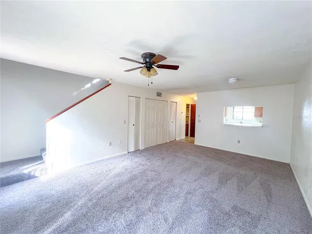 a view of an empty room with a ceiling fan