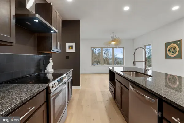 a kitchen with granite countertop a sink and a stove