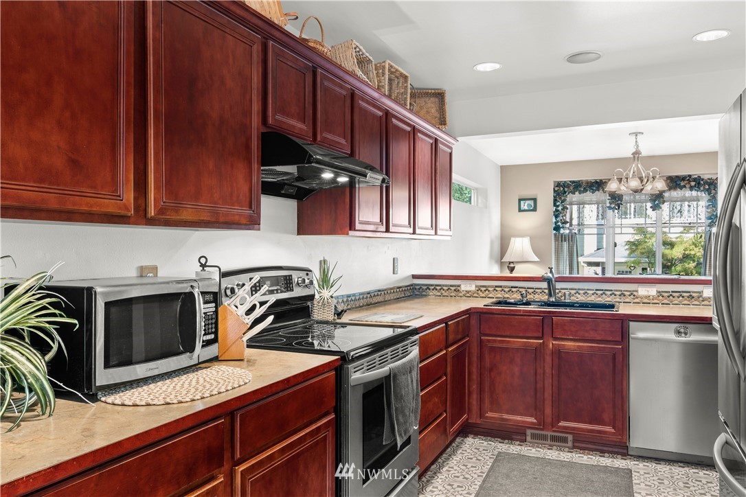 1626 93rd Place Southwest Everett, WA 98204 - Photo 8 of 25 a kitchen with stainless steel appliances granite countertop a sink stove and microwave
