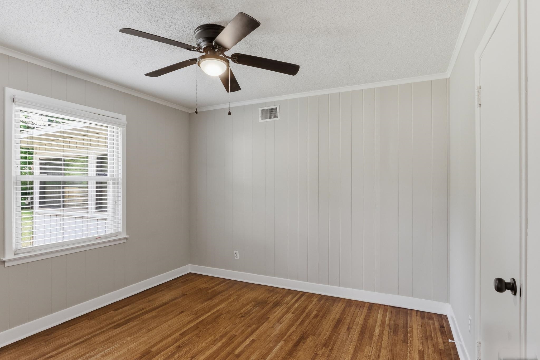312 Fernway Road Memphis, TN 38117 - Photo 28 of 38 Spare room featuring wood walls, dark wood finished floors, crown molding, a textured ceiling, and ceiling fan