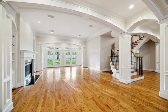 a view of empty room with wooden floor and fireplace