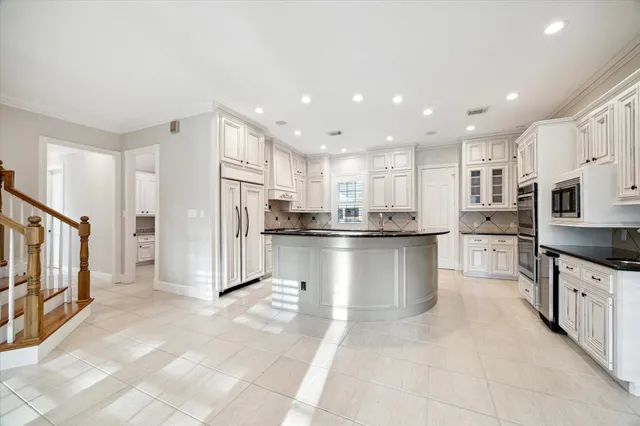 a kitchen with stainless steel appliances granite countertop a refrigerator a stove and a sink
