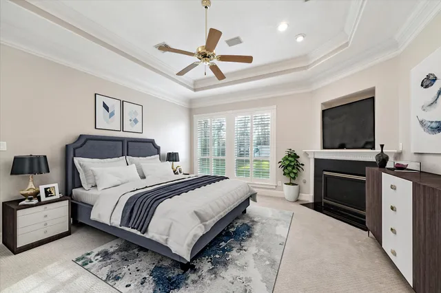 a bedroom with a large bed a flat tv screen and a chandelier