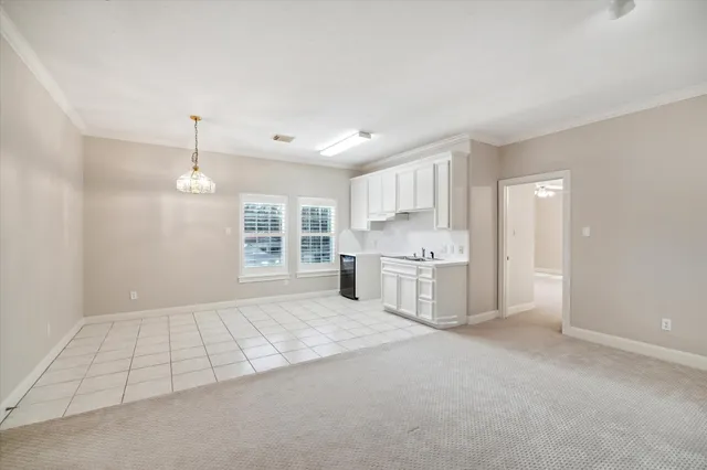 a view of a kitchen with white cabinets and sink