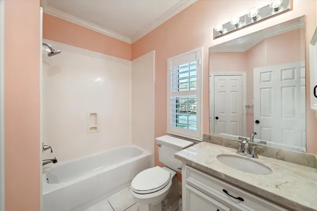 a bathroom with a granite countertop sink a toilet a mirror and shower