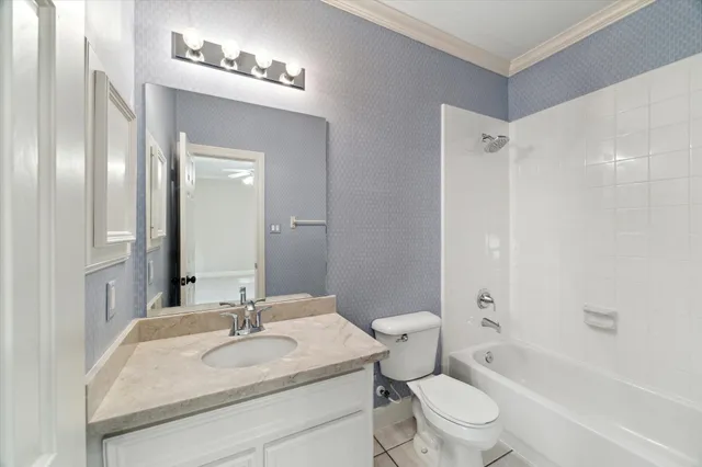 a bathroom with a granite countertop sink a toilet a mirror and shower