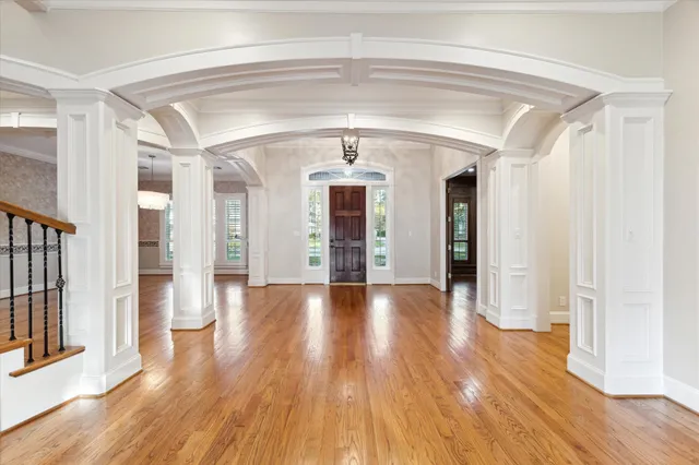 a view of a hallway with wooden floor and staircase