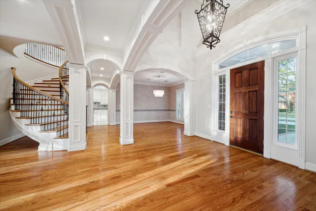 an empty room with wooden floor and entryway