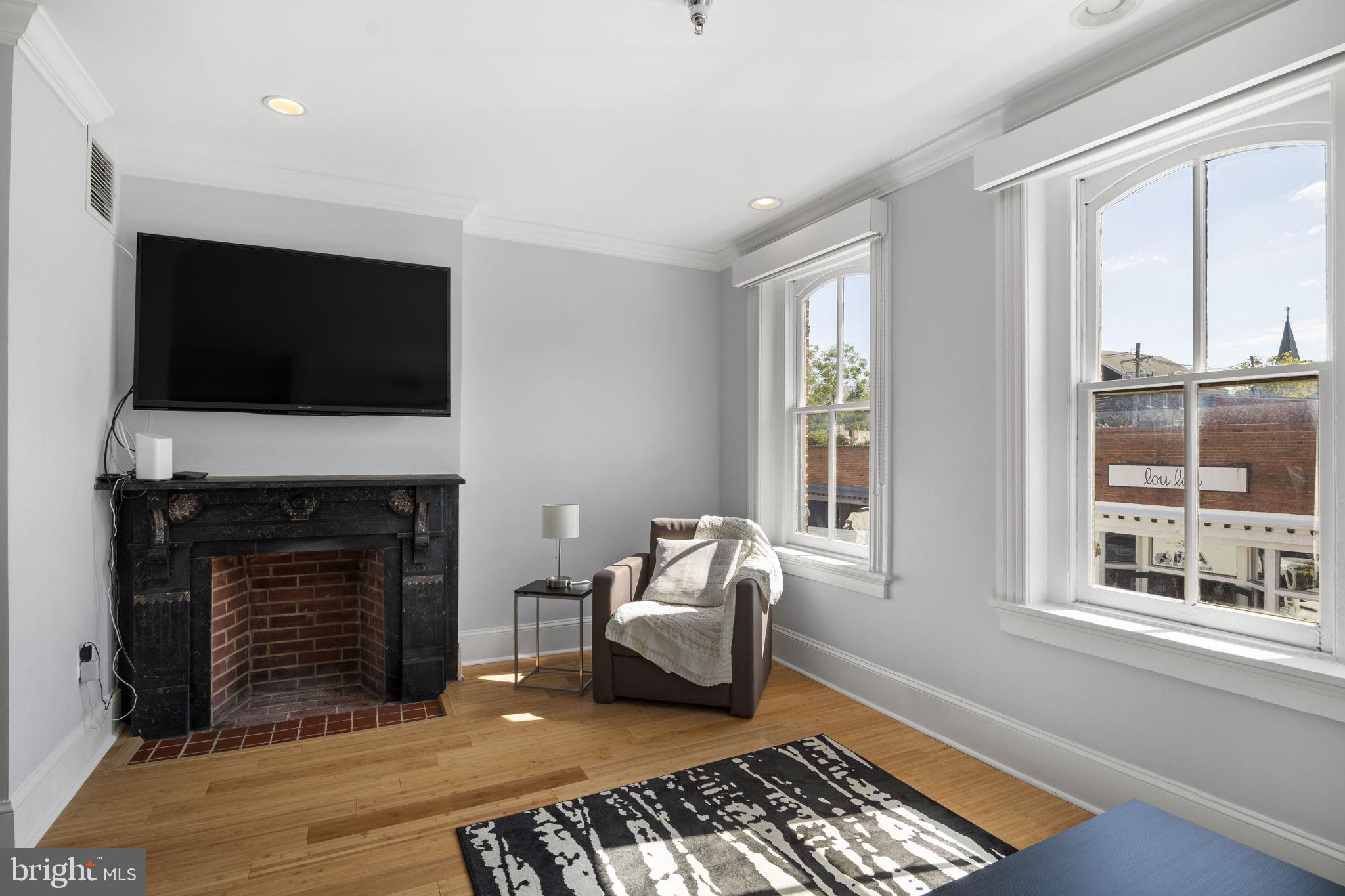 180 Main Street, Unit 202 Annapolis, MD 21401 - Photo 7 of 17 a living room with furniture a fireplace and a flat screen tv