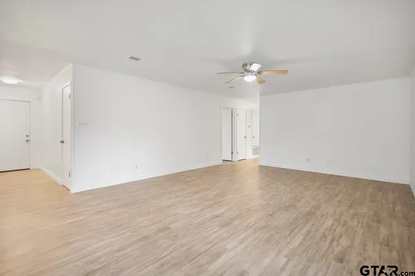 a view of empty room with wooden floor