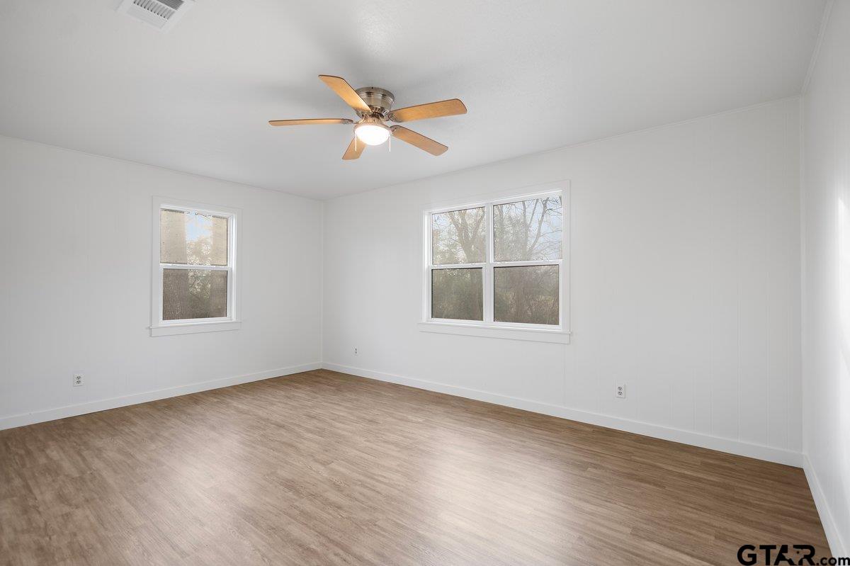 585 Highway 149 Tatum, TX 75691 - Photo 17 of 45 a view of an empty room with wooden floor and a window