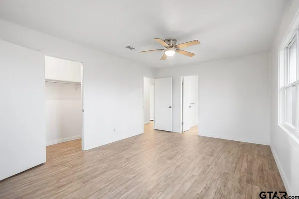 an empty room with wooden floor and windows