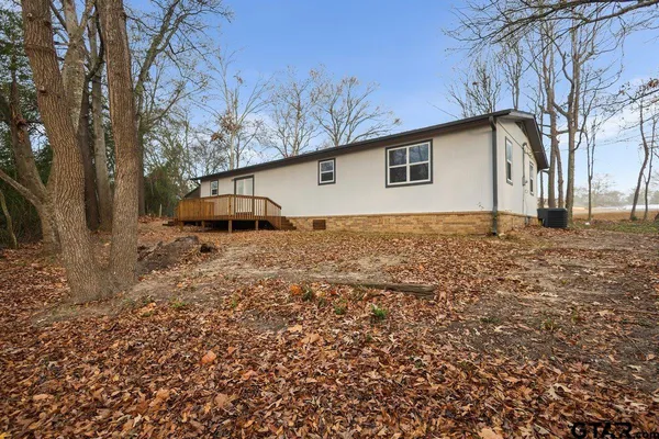 a backyard of a house with garage and trees