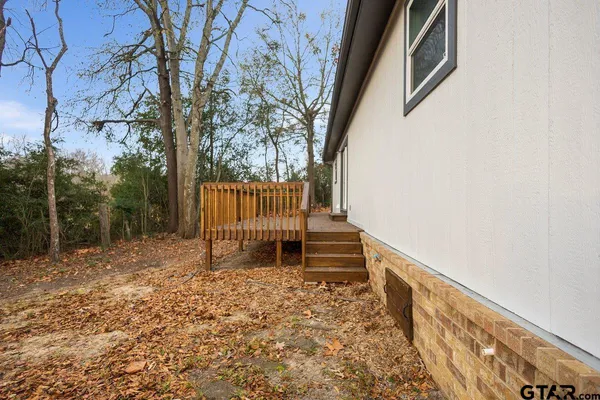 a porch with a bench next to a yard