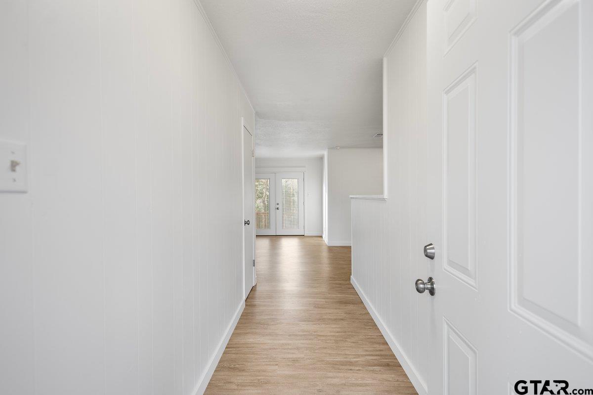 585 Highway 149 Tatum, TX 75691 - Photo 4 of 45 a view of a hallway with wooden floor and a bathroom