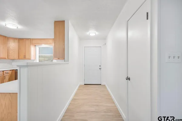 a view of a hallway with wooden floor and a large window