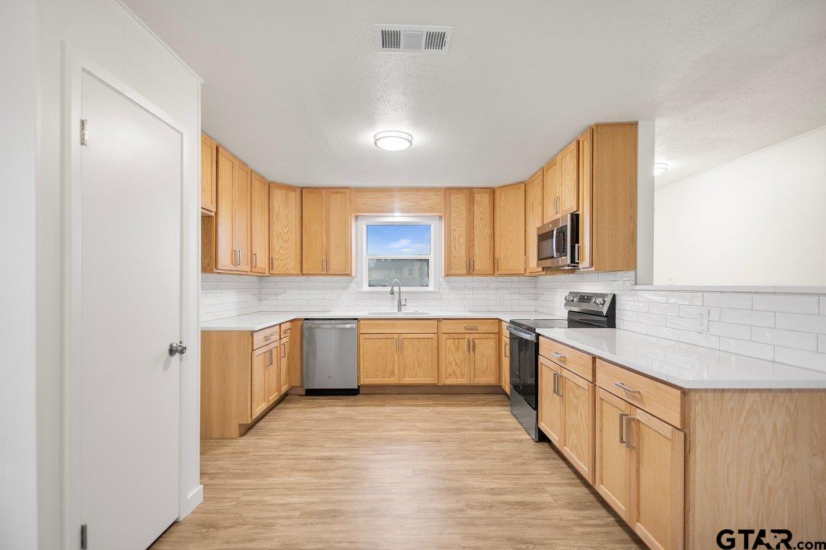 585 Highway 149 Tatum, TX 75691 - Photo 6 of 45 a large kitchen with stainless steel appliances granite countertop a sink and cabinets