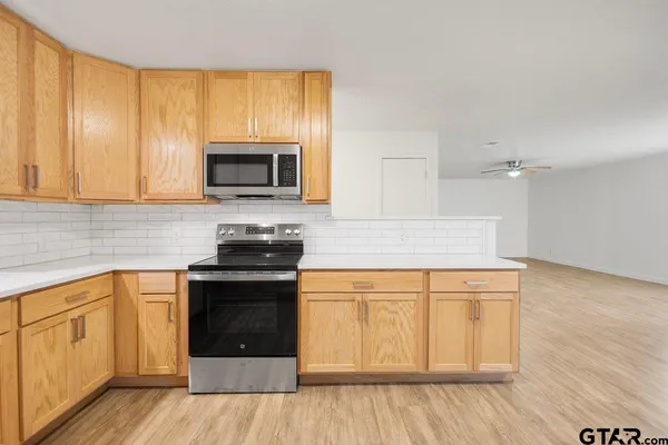 a kitchen with granite countertop wooden cabinets and a stove top oven