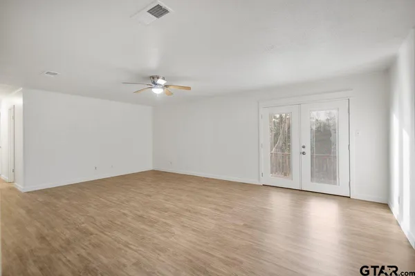 a view of an empty room with wooden floor