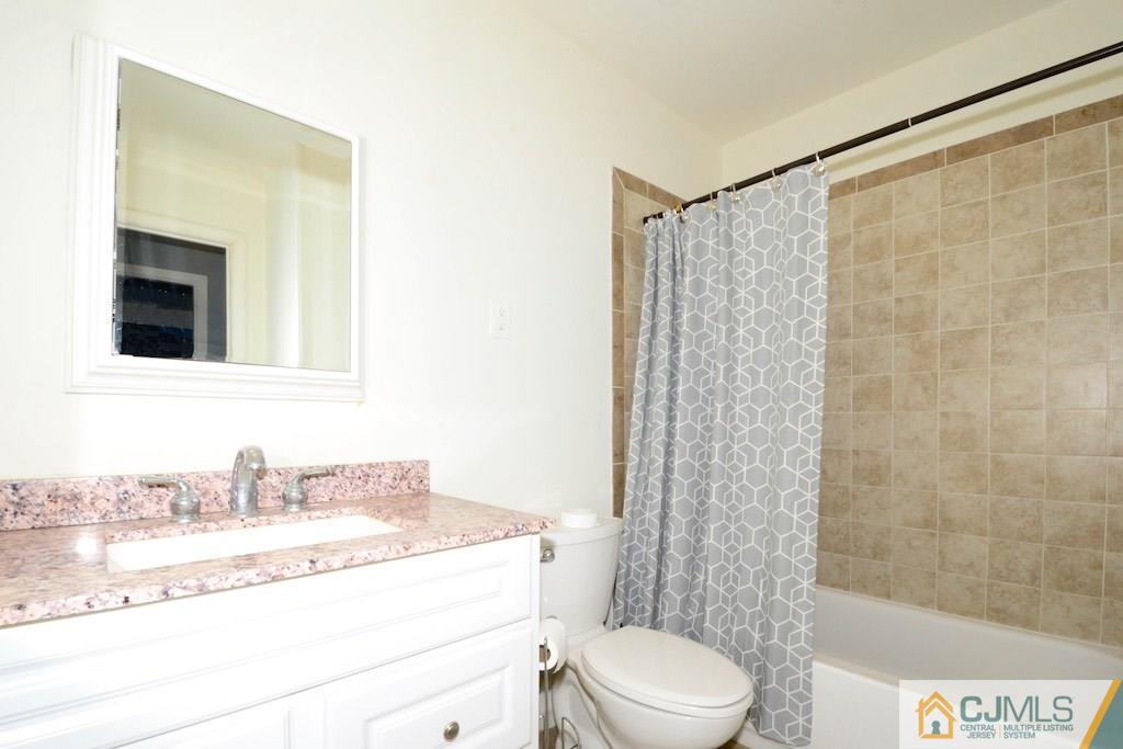 135 Drake Road Somerset, NJ 08873 - Photo 14 of 16 a bathroom with a granite countertop sink a toilet a mirror and shower